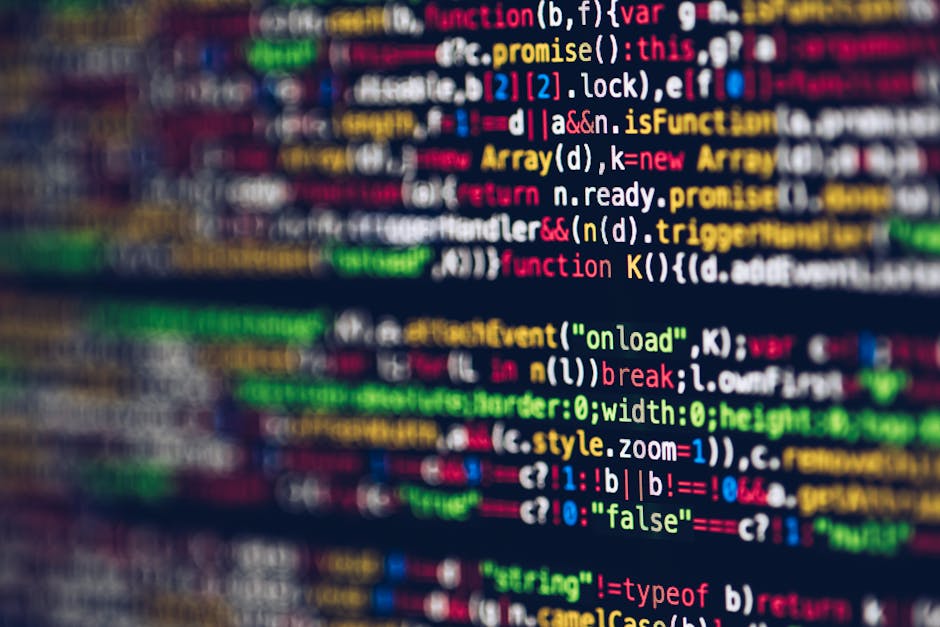 A close-up photograph of a computer screen displaying lines of colorful programming code set against a dark background. The code includes various syntax elements such as function calls, variable decla